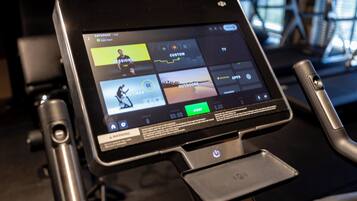 A digital display on a stationary bike showing workout options.