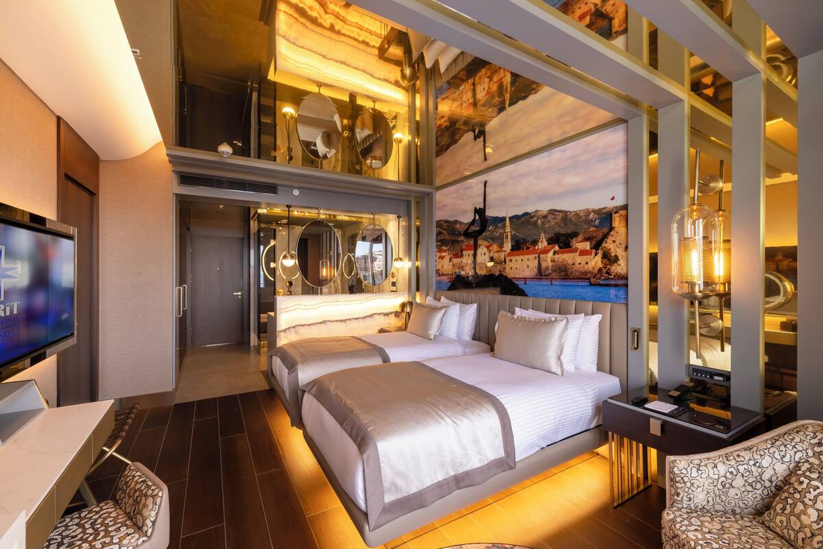 Une chambre d’hôtel moderne, dotée d’un grand lit, d’un bureau et d’une télévision.