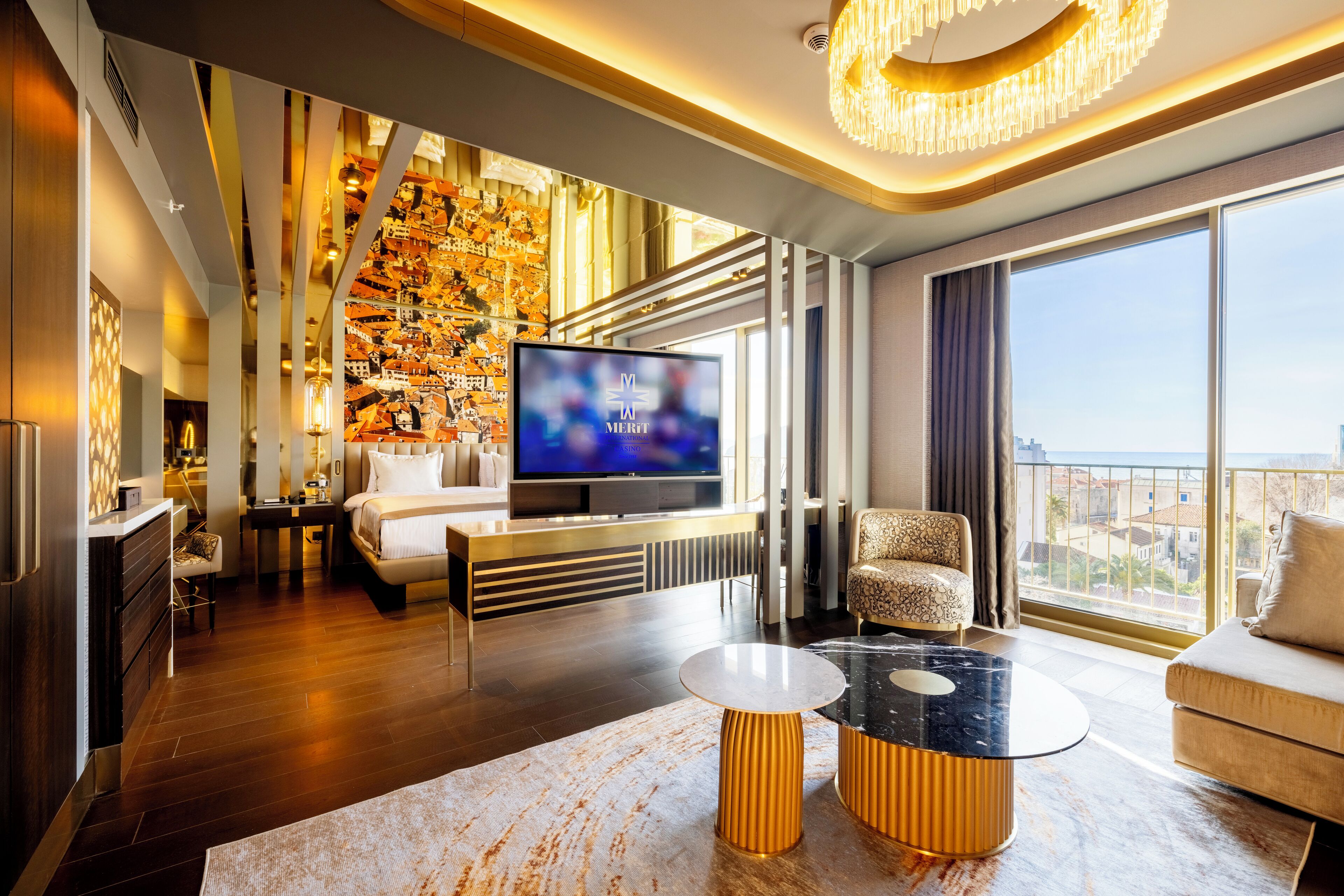 A modern living room with a large flat-screen TV, a sofa, a coffee table, and a city view through large windows.
