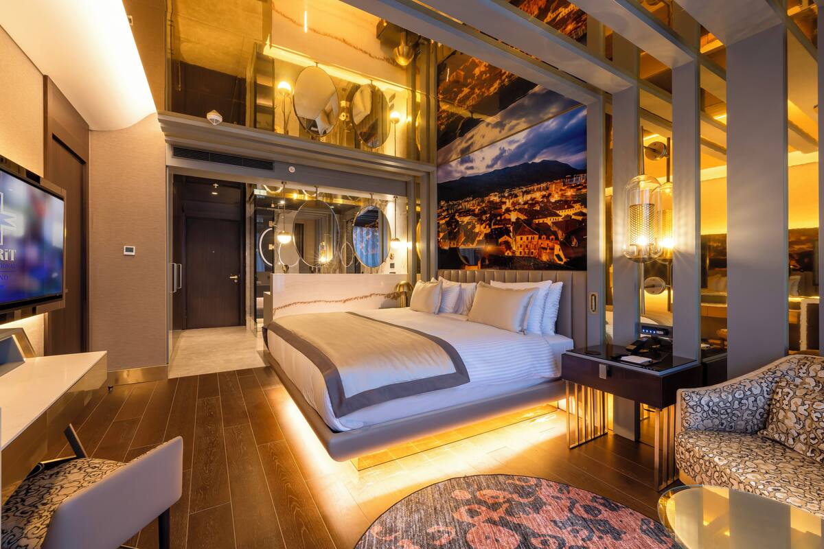 Une chambre d’hôtel moderne dotée d’un grand lit, d’un coin salon et d’une télévision.