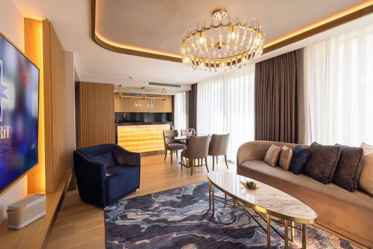 Un salon moderne comprenant un canapé, des fauteuils, une table basse et un téléviseur.
