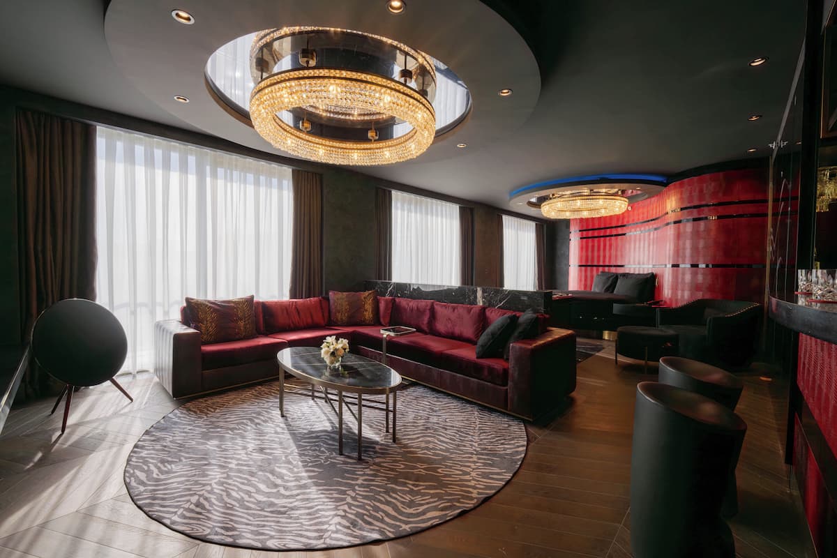 Un salon moderne avec un canapé d’angle, une table basse ronde et un tapis à motifs zébrés.