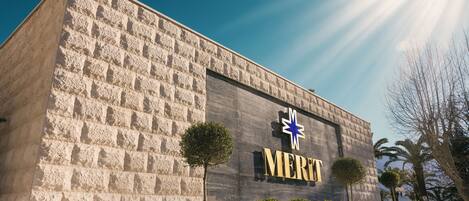 A building with a stone facade and a sign that reads "MERIT."