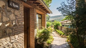 Un edificio de piedra con una puerta de madera y un letrero que dice "El Refugio".