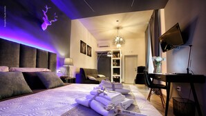 A modern hotel room with a large bed, a desk, a chair, and a TV. - Bourbon House (Naples)
