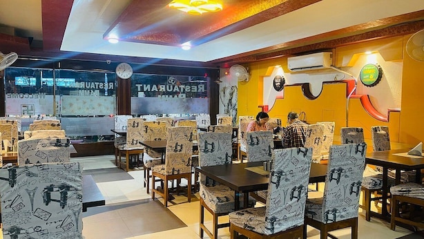 Un ristorante con sedie e tavoli decorati, un orologio e un cartello con su scritto "RESTAURANT".