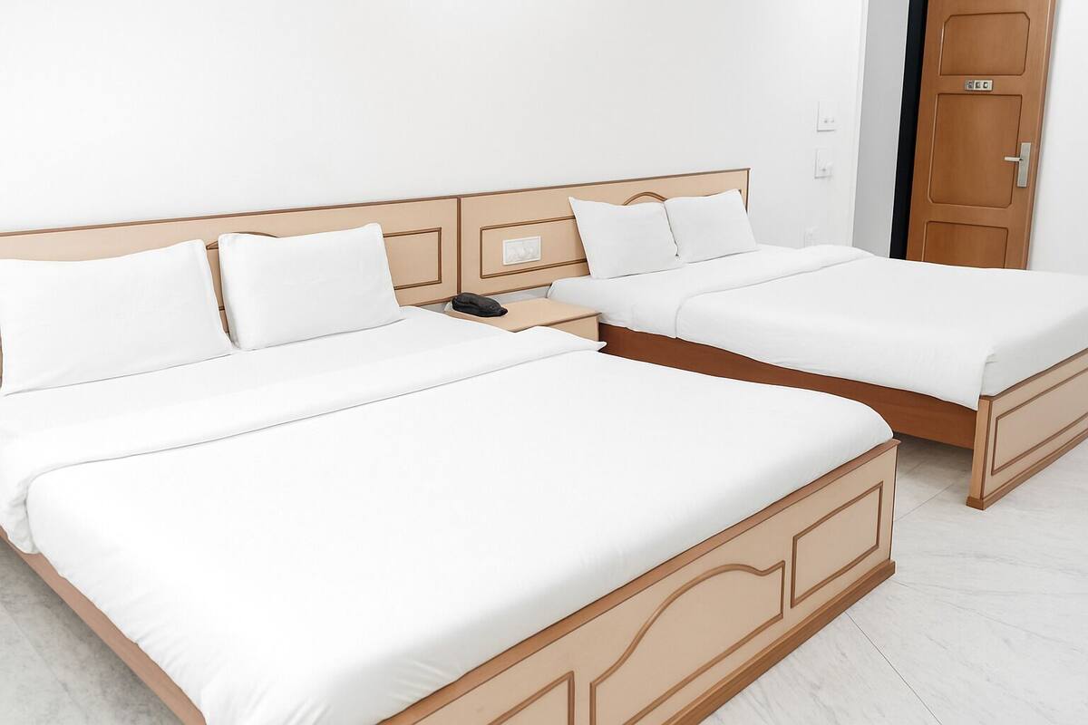 A double bed with a wooden headboard and white bedding.