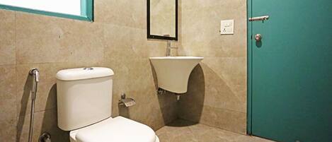 A bathroom with a toilet, sink, and a door.