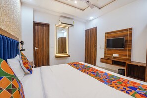 A modern bedroom with a large bed, a TV mounted on the wall, and a mirror above the door. - Fabhotel Grand Inn Ii (Agra)