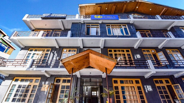 A multi-story building with a prominent 'fab hotels' sign, large windows, and a distinctive wooden overhang. - Fabhotel Suvidha Cottage (Manali)