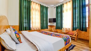 A wooden room with a bed, a TV, and a desk. - Fabhotel Suvidha Cottage (Manali)