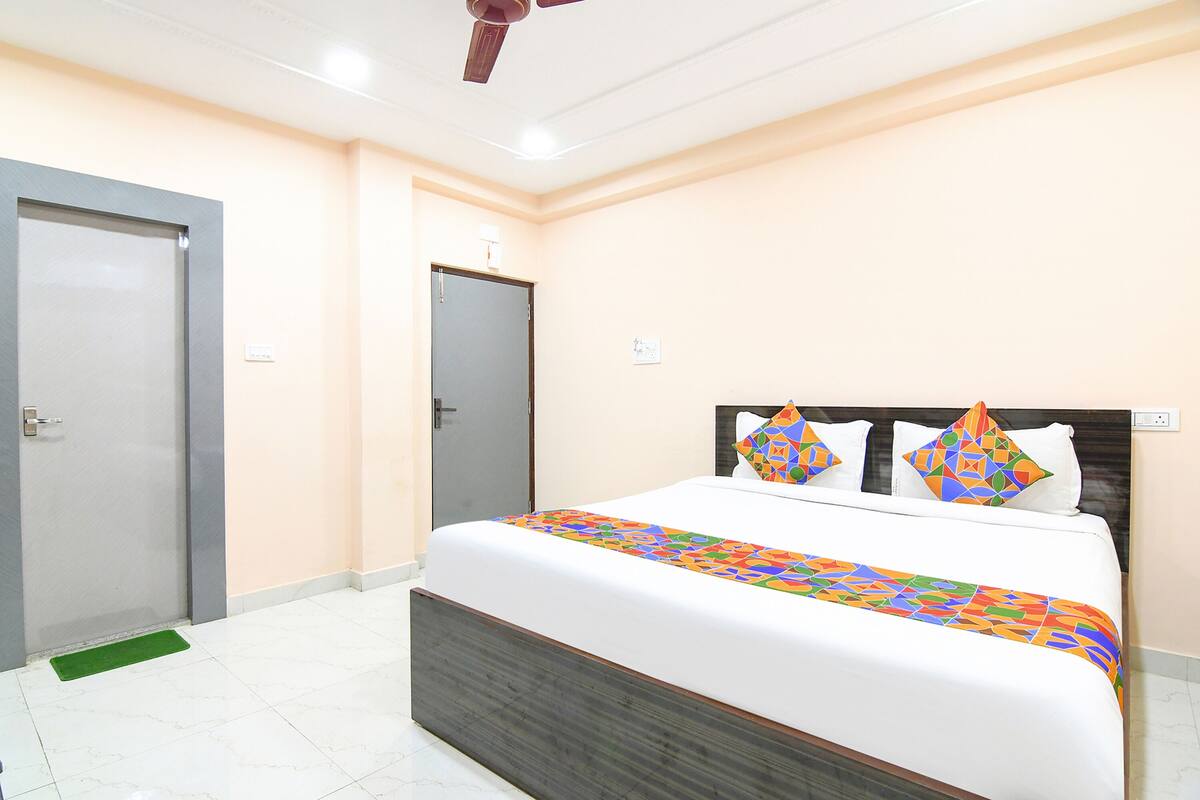 A bedroom with a bed, a door, and a ceiling fan.