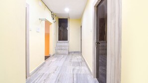 A hallway with a marble floor, a staircase, and a door. - Fabhotel Olive Inn I (Barasat)
