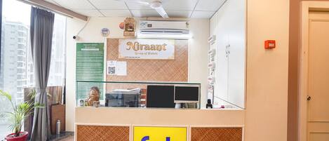 A reception area with a sign for 'Nraant Group of Hotels' and 'fab Hotels'.