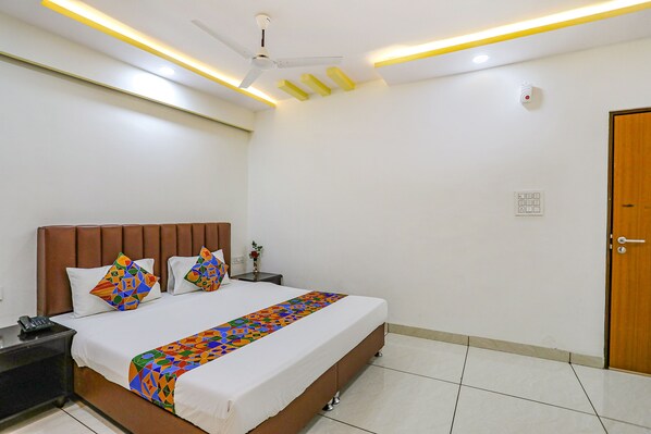 Relax in a cozy retreat with a comfortable bed, bedside table, and convenient telephone.