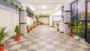 A corridor with potted plants, tiled flooring, and a checkered pattern. - FabHotel Eminent Suites Banjara Hills - Nr. LV Prasad EYE Institute (Hyderabad)