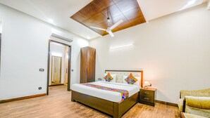 Un dormitorio con cama de madera, mesita de noche, armario y ventilador de techo.