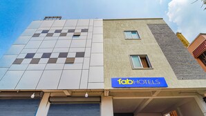 Un edificio con un letrero de 'fab hotels', un garaje y una puerta con persiana azul.
