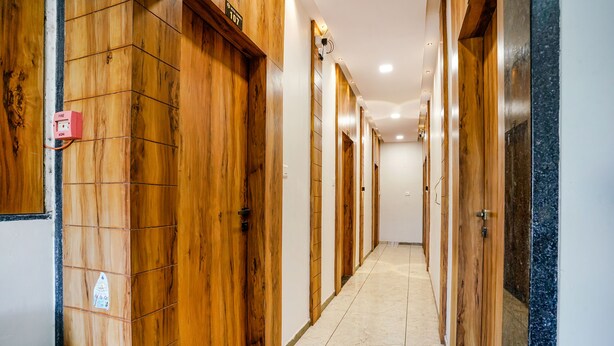 Un pasillo de hotel con puertas de madera y suelo de baldosas.