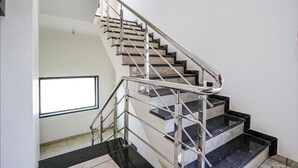 Una escalera con barandillas de metal y escalones de mármol negro.