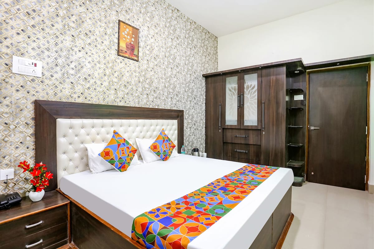 Habitació d'hotel ben ordenada amb un llit gran, un armari i una decoració de paret.
