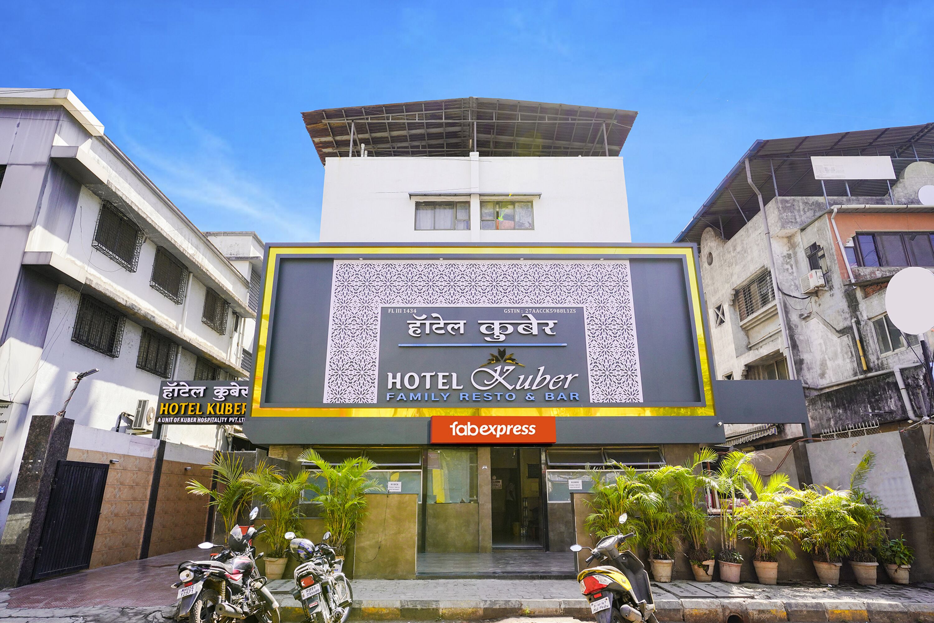 Ett hotell med en skylt där det står ”HOTEL KUBER FAMILY RESTO & BAR” och en logotyp för ”fabexpress”.