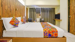 A hotel room with a large bed, a desk, a chair, a television, and a wardrobe. - FabHotel Kuber (Navi Mumbai)