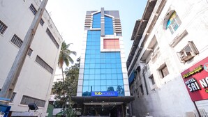 A tall building with a modern facade, featuring a prominent logo at the top. - Fabhotel Sai National (Visakhapatnam)