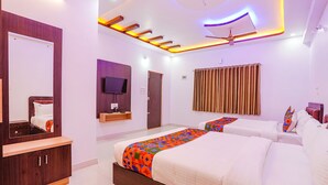 A modern hotel room with a large bed, a TV, a wardrobe, and a ceiling fan. - Fabhotel Sri Ram Comforts (Bengaluru)