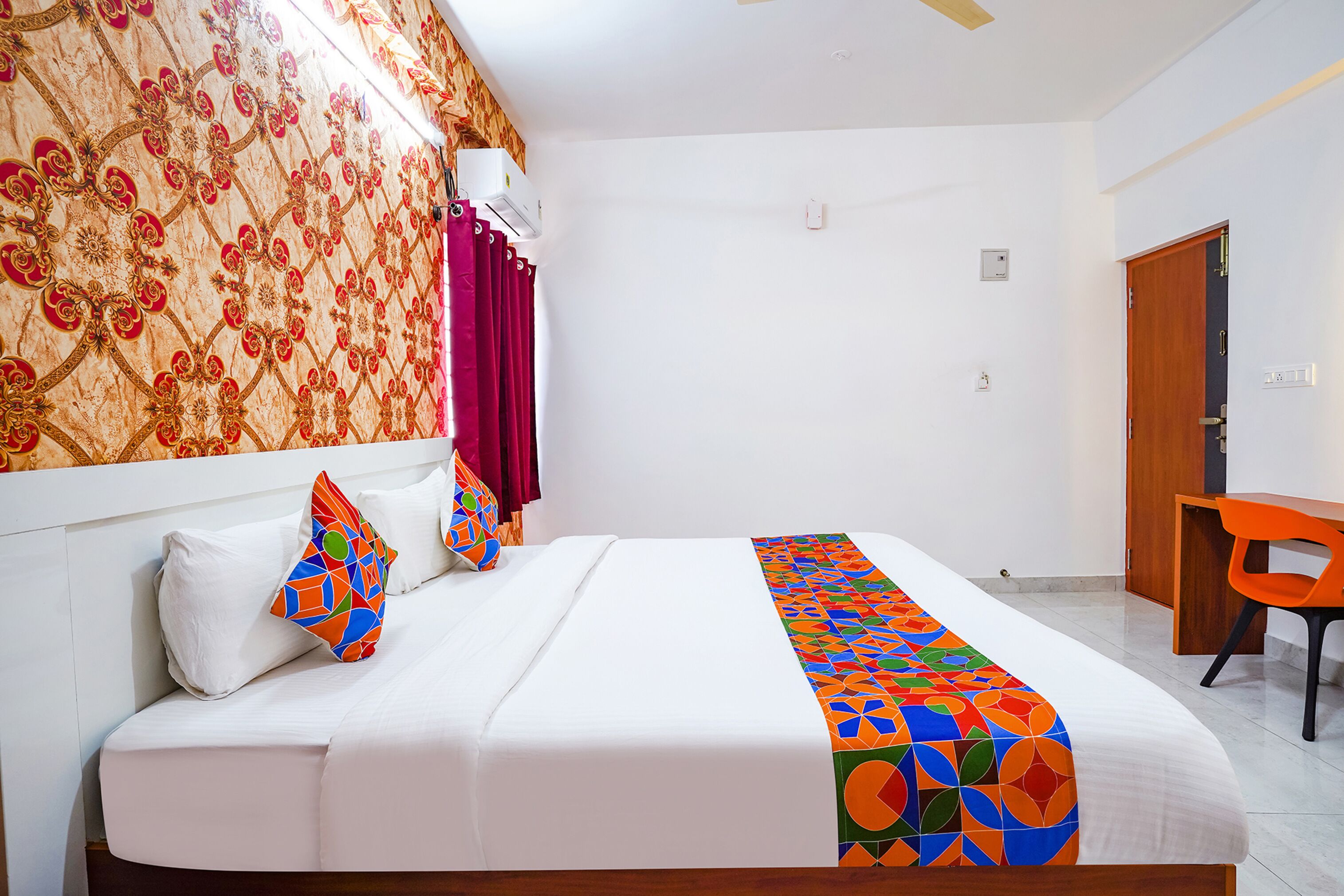 Una habitación de hotel con una cama bien hecha, un escritorio y una silla.