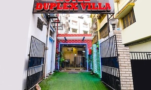 The entrance to Duplex Villa with a gated driveway and a small lawn area.