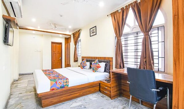 A bedroom with a bed, desk, chair, and a window with curtains. - Fabexpress Duplex Villa (Barasat)