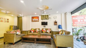 A living room with two sofas, a coffee table, a TV, and a ceiling fan. - Via Peaceful Stay Palam (New Delhi)