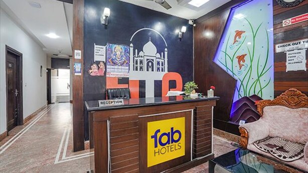 A reception desk with a 'fab hotels' sign, a wall with a mosque illustration, and a 'no smoking' sign. - Fabexpress Taj Prince (Agra)