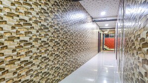A corridor with a textured wall on one side and a plain wall on the other. - FabHotel The Royal Heritage (Mahabaleshwar)