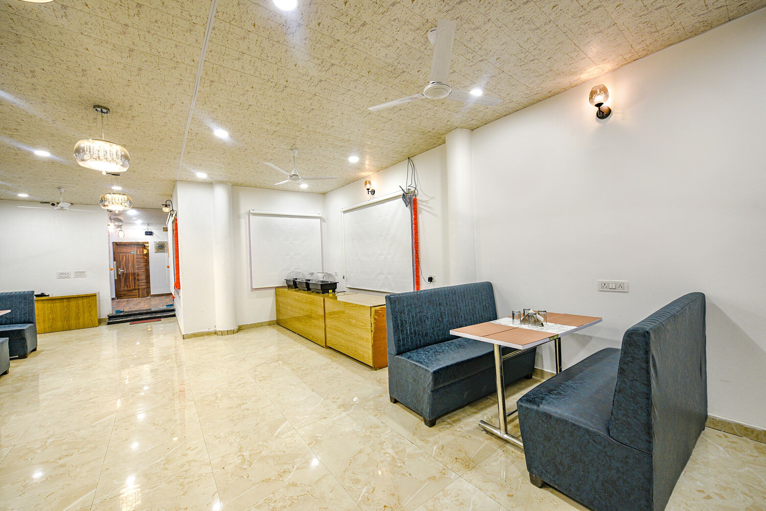 A spacious room with a high ceiling, a blue sofa, a small table, and a wooden cabinet.