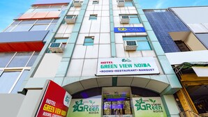 Um hotel chamado "Green View Noida" com placas indicando quartos, um restaurante e um salão de festas.