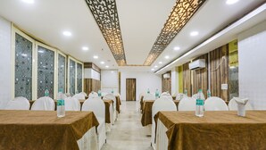 A conference room with rows of tables, chairs, and water bottles. - Fabhotel Spb 87 (New Delhi)
