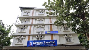 Un edificio de varios pisos con un letrero que dice "Dreams Paradise Airport Residency".