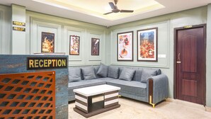 A reception area with a sofa, a coffee table, and framed pictures on the wall. - FabHotel Hari Kunj 900 m from Kashi Vishwanath Temple (Varanasi)
