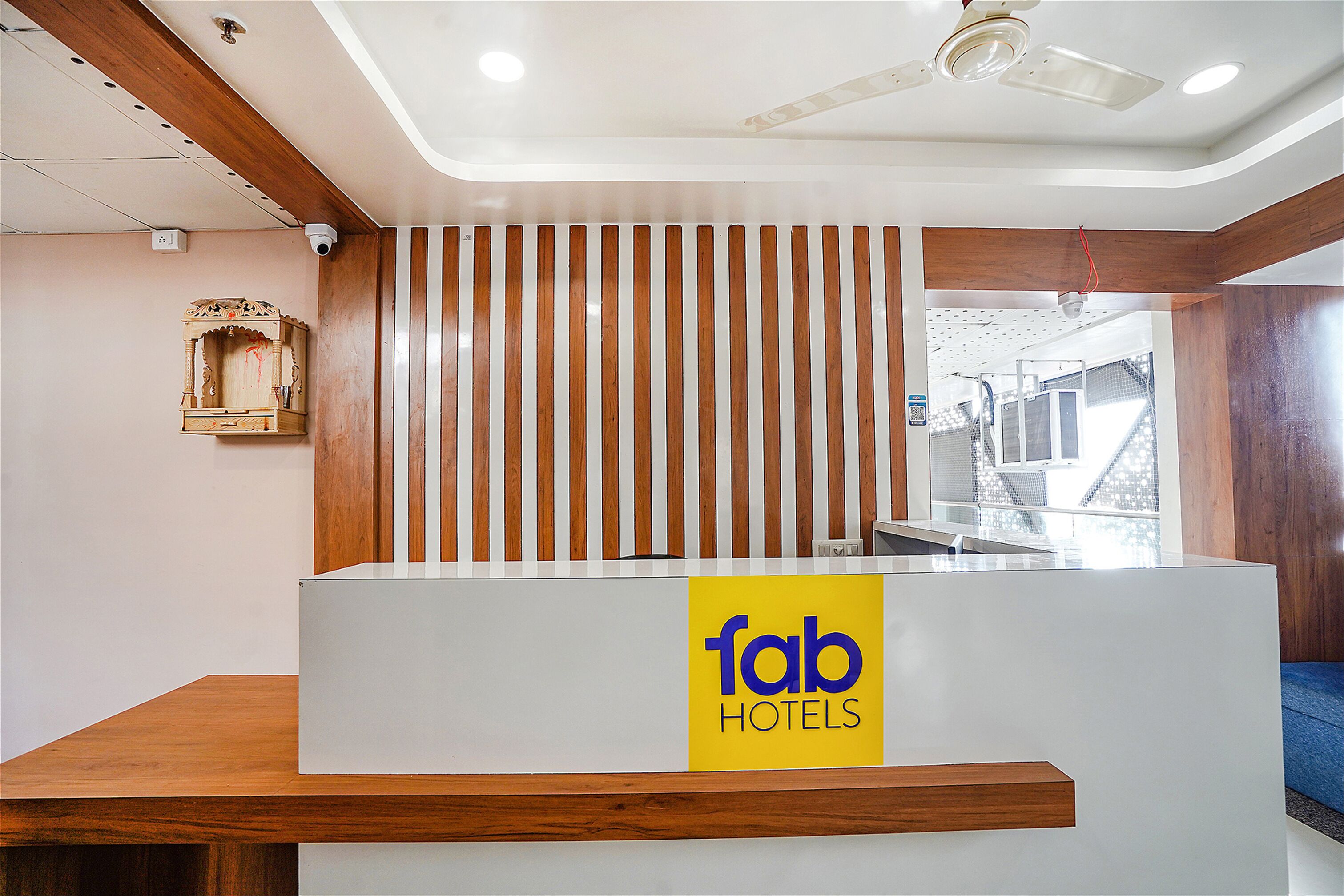 Una reception con un pannello in legno e un cartello con la scritta 'fab hotels'.