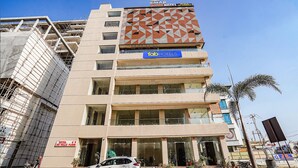 A multi-story hotel with a modern facade, a prominent 'Tab Hotels' sign, and a visible entrance with a car parked in front. - Fabhotel Hk Villa (Vadodara)