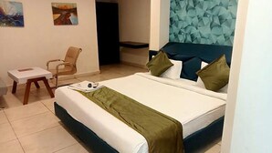 Una habitación de hotel con una cama, una silla y una pequeña mesa.