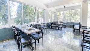 A spacious restaurant with high ceilings, large windows, and a polished floor. - Fabhotel Prime Kantara (Mawal)