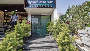 The Grand Vista Inn business hotel entrance with steps leading up to the door, surrounded by potted plants. - Fabhotel Grand Vista Inn (Bengaluru)