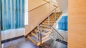 A modern staircase with metal railings and a wooden finish, leading to a higher floor. - Fabhotel Grand Vista Inn (Bengaluru)