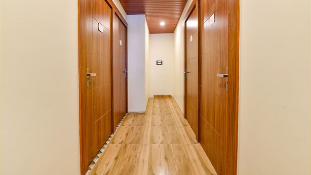 Un pasillo con puertas de madera y suelo de baldosas.