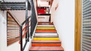 A staircase with alternating red, yellow, and white steps leading to a reception area.
