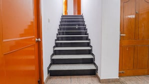 A staircase with black steps and a wooden door at the top. - FabHotel Harma Residency - near Velachery Railway station (Chennai)