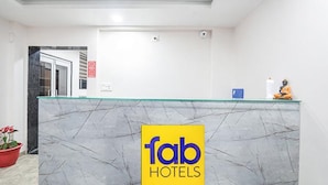 A reception desk at Fab Hotels with a marble top and a glass panel. - Fabhotel Prime Palace View (Vadodara)